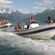 Guests ride a rigid inflatable boat through a fjord